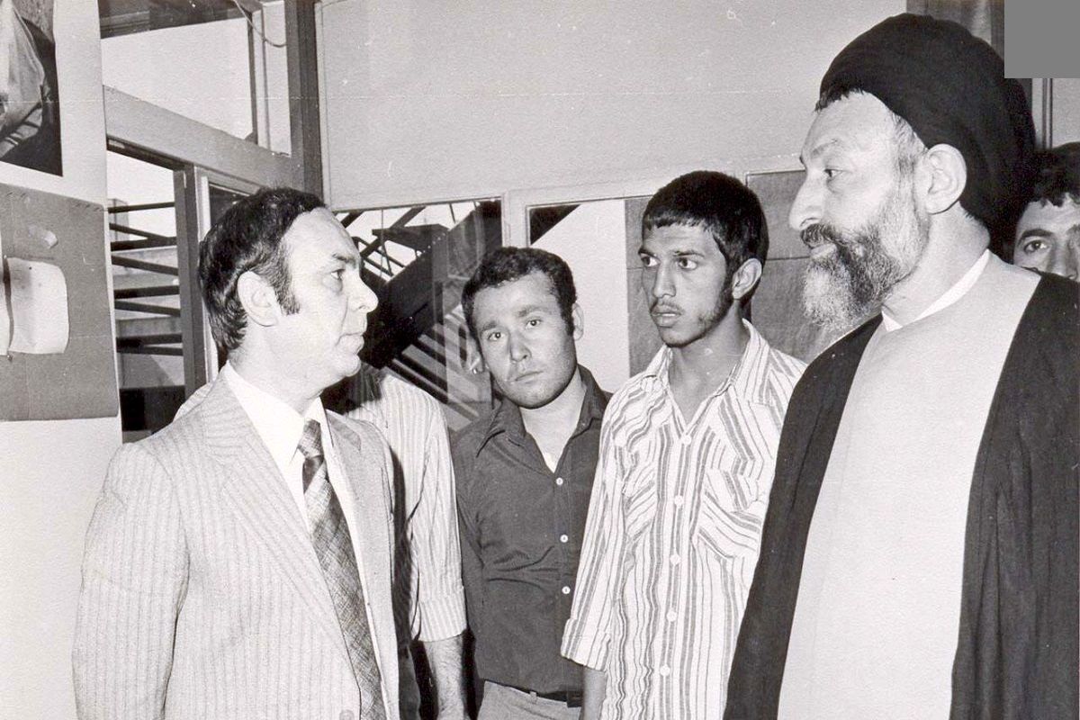 شهید بهشتی در لحظه به خاک سپردن آیت‌الله طالقانی/ عکس