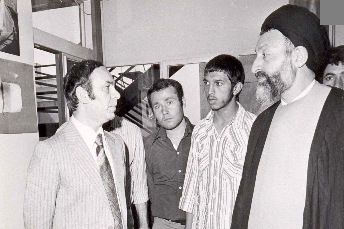 شهید بهشتی در لحظه به خاک سپردن آیت‌الله طالقانی/ عکس